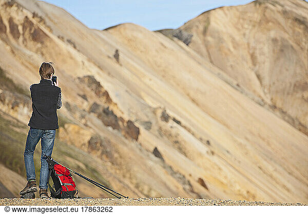 teenage boy takes picture at Landmannalaugar - a geothermal area