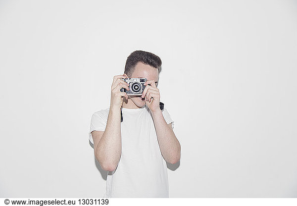Teenage boy using retro camera