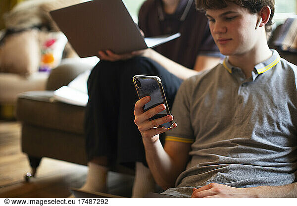 Teenage boy using smart phone at home
