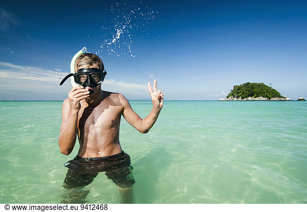 teenage boy with snorkeling equipment showing victory-sign  Koh Lipe  Thailand