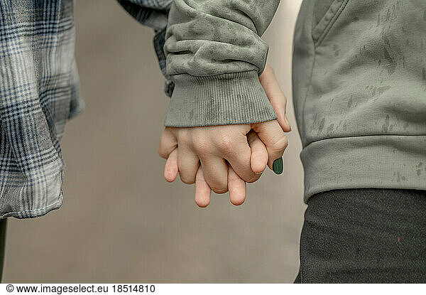 Teenage brother and sister holding hands on rainy day