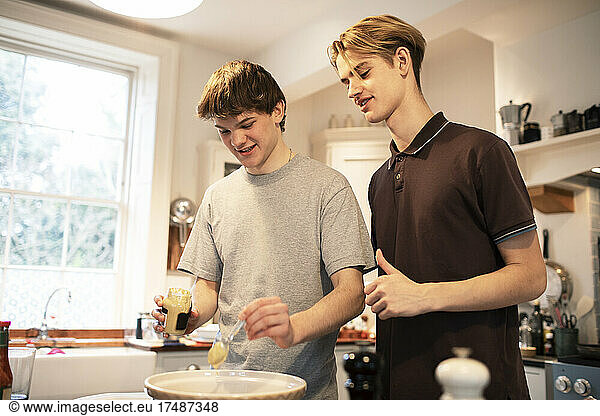 Teenage brothers cooking in kitchen