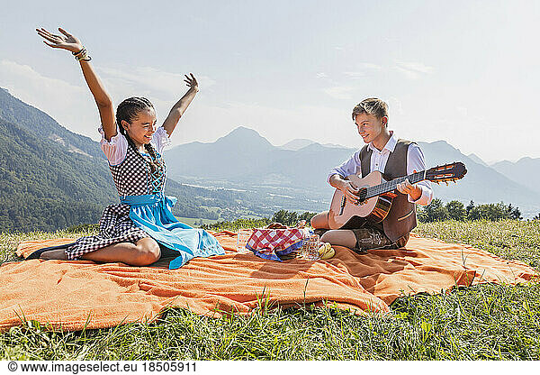 Teenage friends enjoying with guitar during picnic  Bavaria  Germany