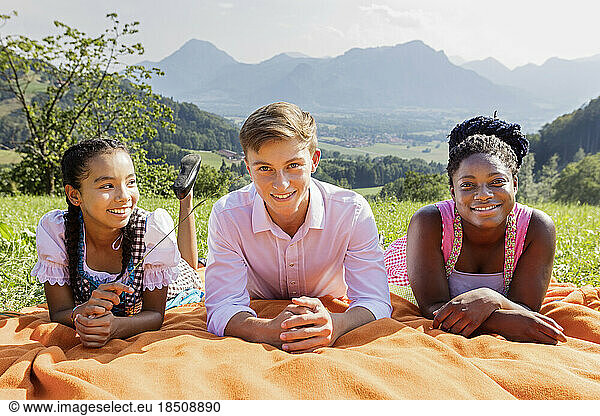 Teenage friends lying on picnic blanket  Bavaria  Germany