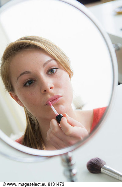 Teenage girl applying lip gloss