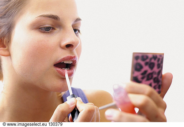 Teenage girl applying makeup