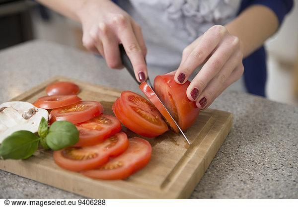 Teenage girl cutting tomatoes  close up
