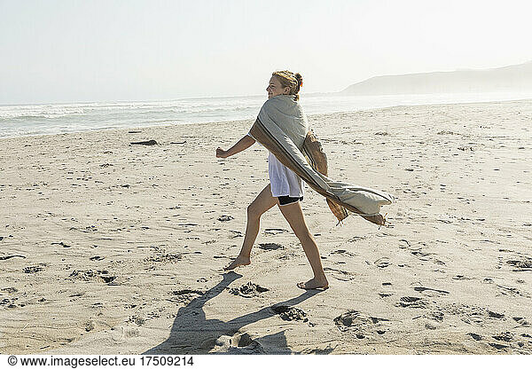 Teenage girl dancing on a sandy beach