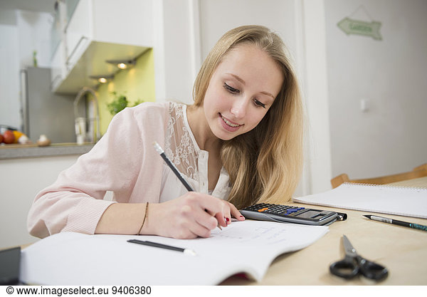 Teenage girl doing homework  smiling