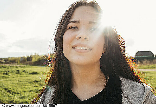 Teenage girl in field at sunny day