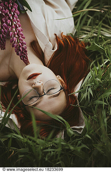 Teenage girl lying on grass with eyes closed