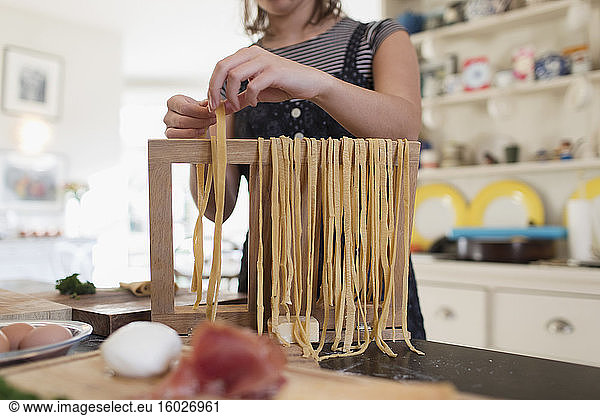 Teenage girl making fresh homemade pasta in kitchen