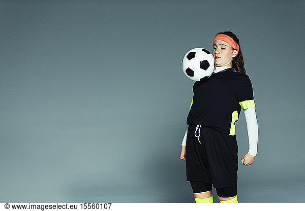 Teenage girl soccer player balancing ball on chest