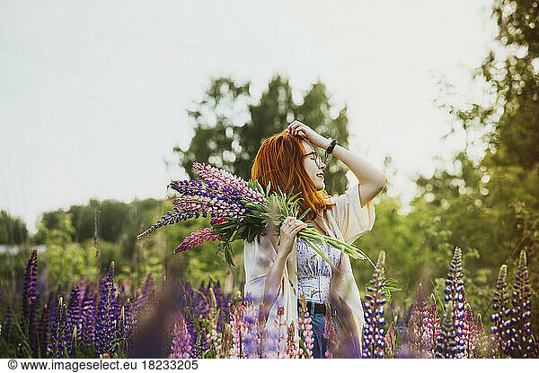 Teenage girl standing with bouquet of lupin flowers