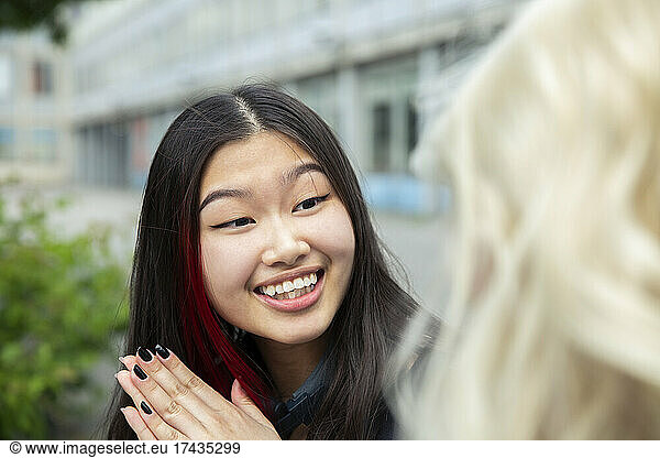 Teenage girl talking with female friend