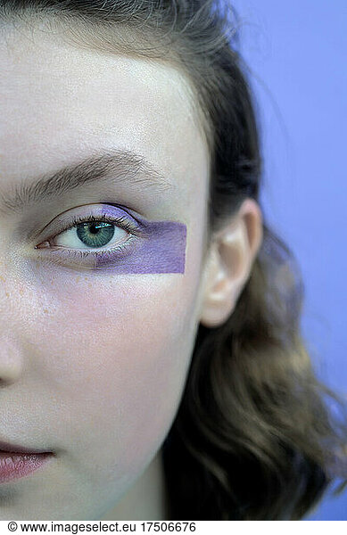 Teenage girl with make-up on face staring