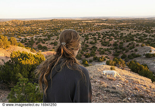 Teenage girland her brother looking down at Galisteo Basin  Santa Fe  at sunset