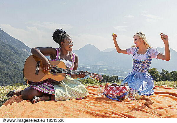 Teenage girls enjoying with guitar during picnic  Bavaria  Germany
