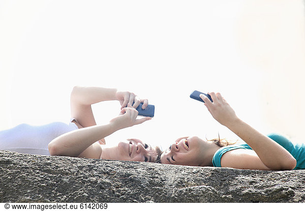 Teenage girls using cell phones outdoors