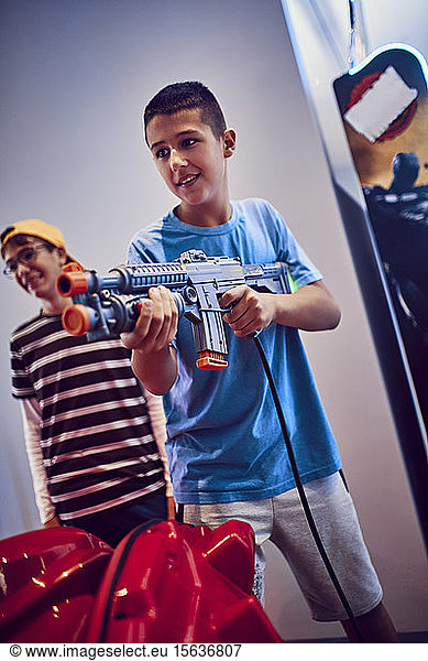 Teenager  der in einer Spielhalle mit einer Waffe schießt