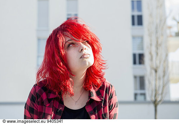 Teenager girl bright red hair day-dreaming