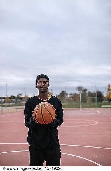 Teenager hält Basketball