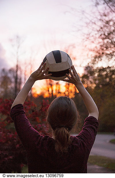 Teenager Junge wirft Ball bei Sonnenuntergang