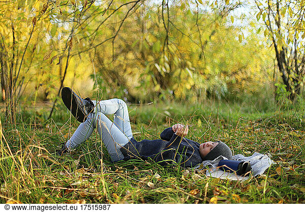 Teenager lies on the grass and rests in the park