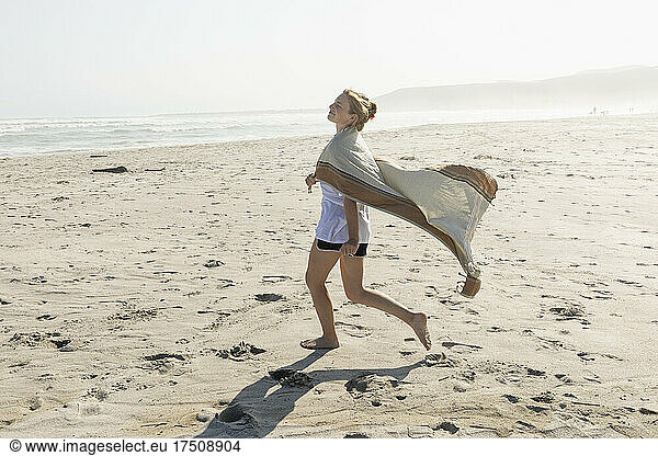 Teenager-Mädchen tanzt auf einem Sandstrand