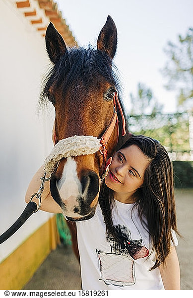 Teenager with down syndrome hugging her horse Teenager with down