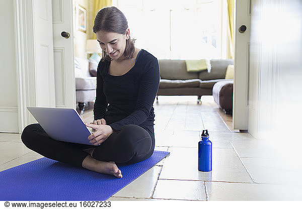 Teenagerin beim Online-Yoga-Kurs mit Laptop