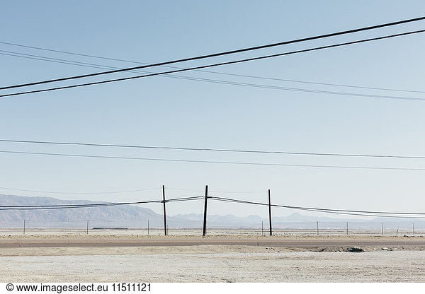 Telefonmasten und Stromleitungen in der Nähe von Trona  Kalifornien  USA.