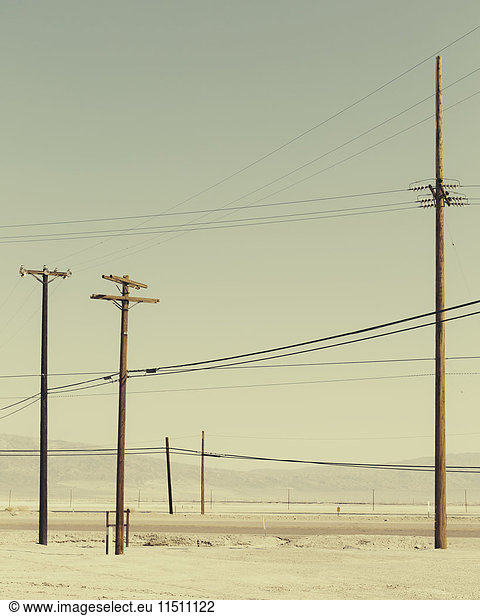 Telefonmasten und Stromleitungen in der Nähe von Trona  Kalifornien  USA.
