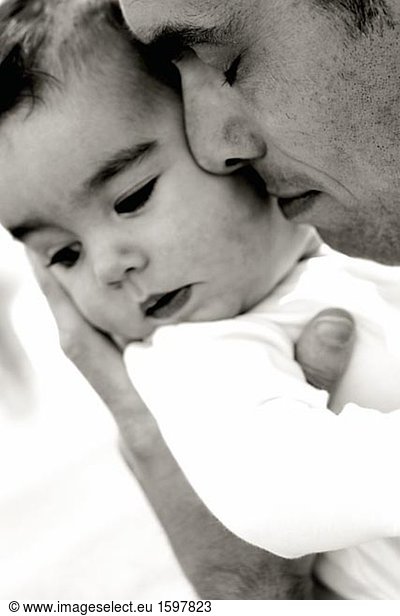 Tender moment with father and child .