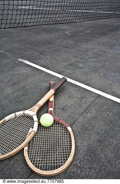 Tennis rackets and ball on court
