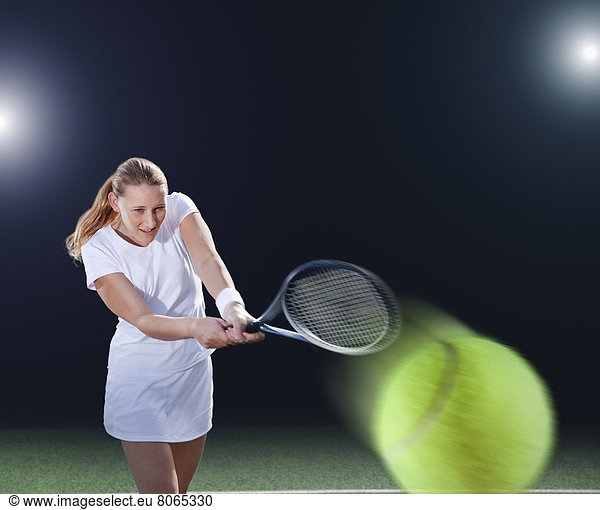 Tennisspieler schlägt Ball auf dem Platz