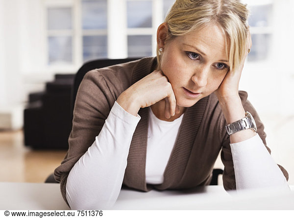 Tensed mid adult business woman at desk