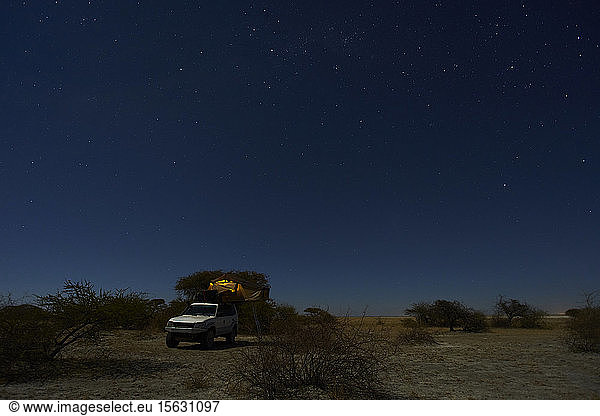 Tent on off-road vehicle on field against sky at night  Makgadikgadi Pans  Botswana