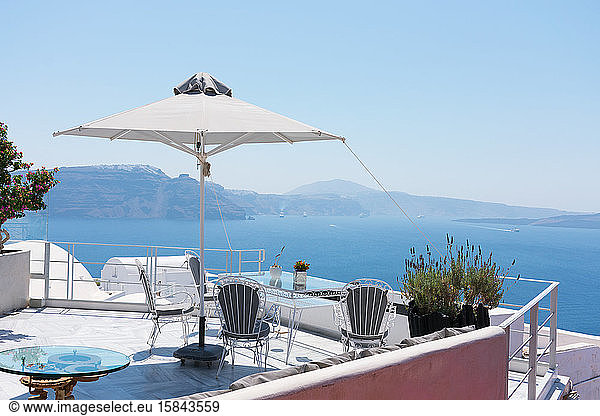 Terrace with nobody in the greek island of Satorini with the best landscape of the Aegean sea with ships and the Caldera of the volcano with the main town of Fira at the top of the cliff. Hor