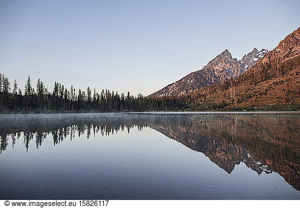 Tetons reflected in the still waters of String Lake at sunrise