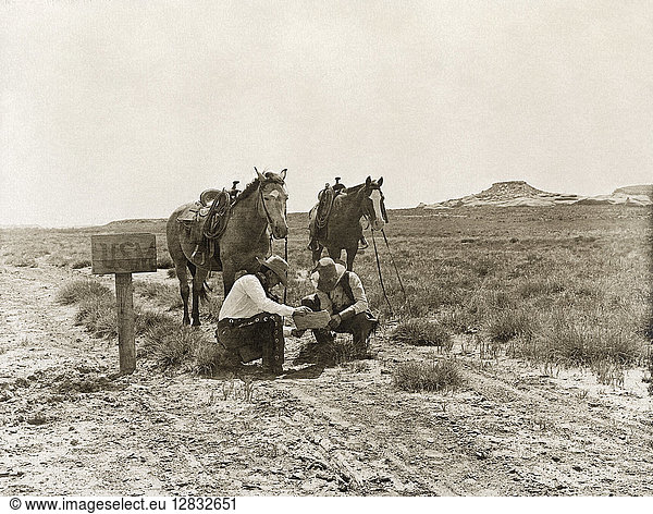 TEXAS: COWBOYS  c1907. Two cowboys reading mail next to a 'USM' postbox near the LS Ranch in Texas. Photograph by Erwin Evans Smith  c1907.
