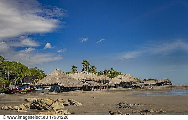 Thatched roof restaurants near the beach  thatched roof restaurant near wooden boats with blue sky  nicaragua restaurants near the beach