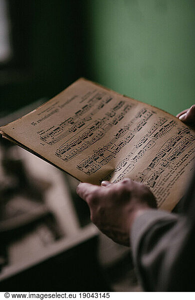 The artist holds the music notebook.