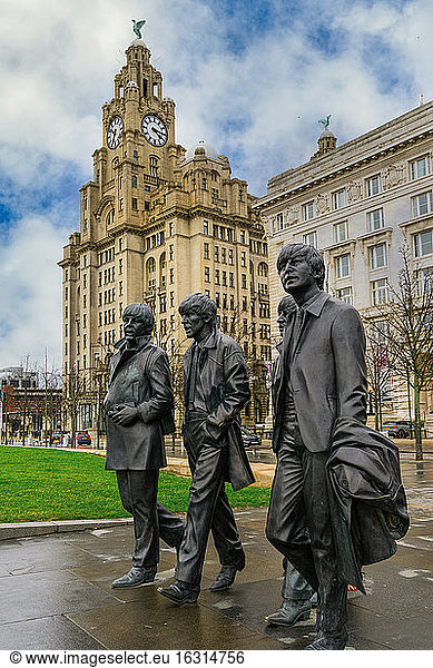 The Beatles statue  bronze art depicting the famous band facing river Mersey with Royal Liver Building in the background  Liverpool  Merseyside  England  United Kingdom  Europe