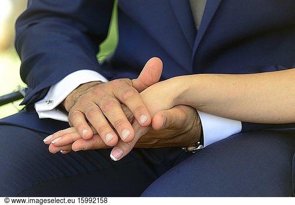 The bride and groom hold hands at the wedding ceremony
