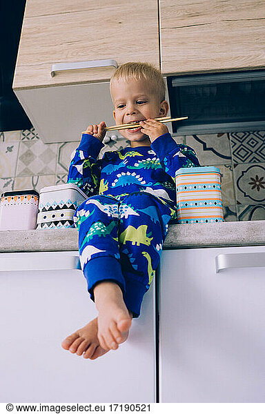 The child plays in the kitchen in the morning