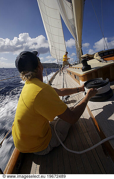 The crew of a sailboat work together off the coast of St. Bartholomew  British West Indies.