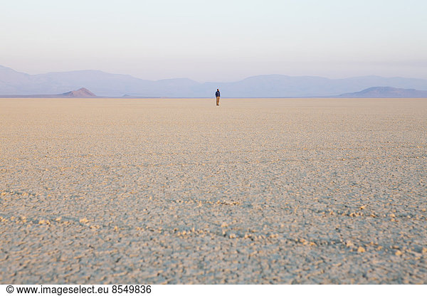 The figure of a man in the empty desert landscape of Black Rock desert  Nevada.