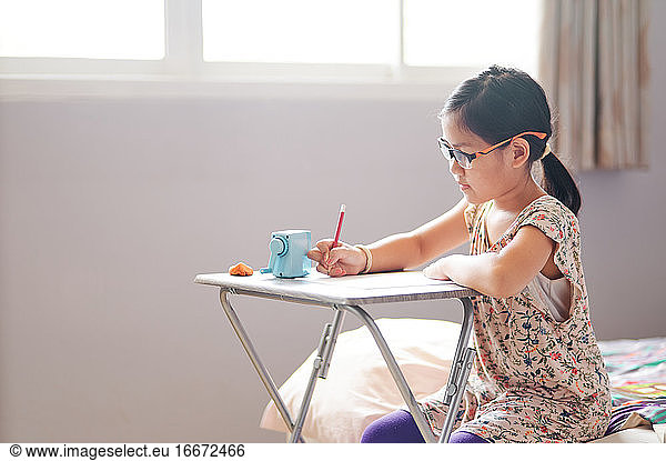 The girl is focused on her job during home school