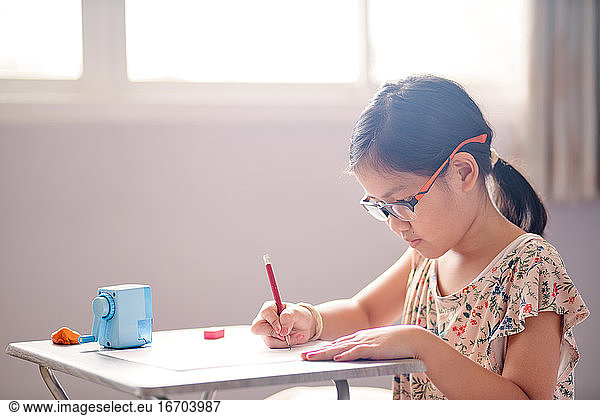 The girl is focused on her job during home school